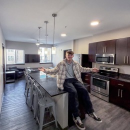 a person sitting on a counter in a kitchen