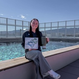 a person sitting by a pool with a cup and box