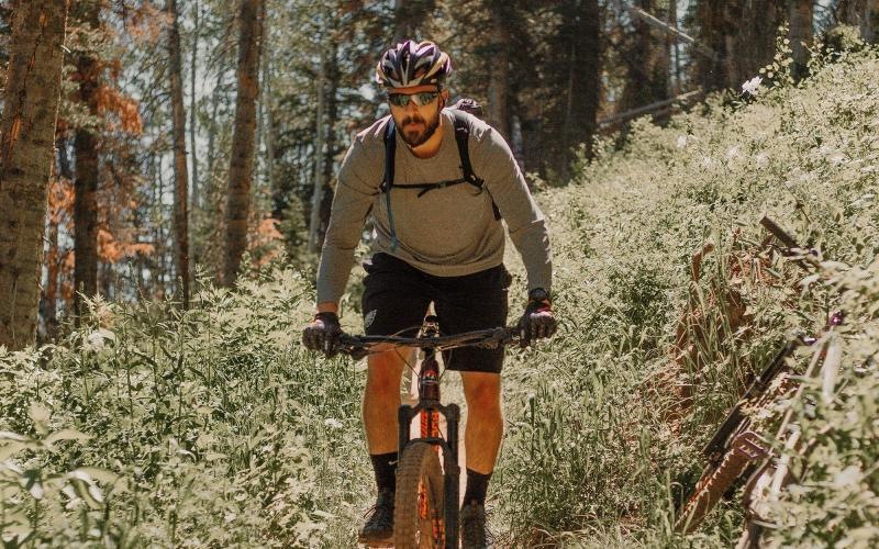 man riding a bike on a trail in the woods